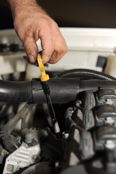 Jerry Cazeault uses a dipstick to check the oil after a brake change on Seymour Johnson Air Force Base, N.C., Dec. 27, 2011. The reading from the dipstick allows a mechanic to know if the oil in a car is too low, which could cause damage to an engine. Cazeault is a 4th Force Support Squadron auto skills development mechanic from Woonsocket, R.I. (U.S. Air Force photo by Senior Airman Whitney Stanfield)