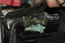 Jerry Cazeault scrubs a battery cable after a brake change on Seymour Johnson Air Force Base, N.C., Dec. 27, 2011. Using battery cleaner, baking soda or Coca-Cola to remove acid from a battery cable prevents damage to the cable so the engine will run smooth. Cazeault is a 4th Force Support Squadron auto skills development mechanic from Woonsocket, R.I. (U.S. Air Force photo by Senior Airman Whitney Stanfield)
