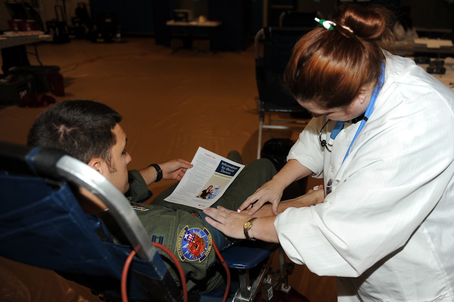 Lois Dryman, American Red Cross technician, prepares U.S. Air Force Capt. Michael Sackenheim, 74th Fighter Squadron A-10C Thunderbolt II pilot, for a blood donation here at Moody Air Force Base, Ga., Dec. 27, 2011. The blood from donors provides relief to victims of disasters and helps people prevent, prepare for, and respond to emergencies. (U.S. Air Force photo by Staff Sgt. Ciara Wymbs/Released)