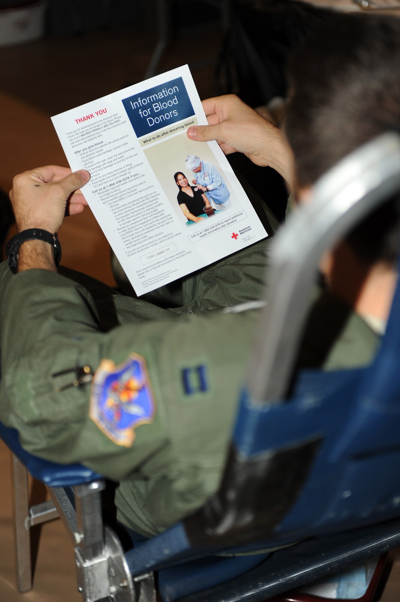U.S. Air Force Capt. Michael Sackenheim, 74th Fighter Squadron A-10C Thunderbolt II pilot, reads an American Red Cross volunteer blood donor information sheet at Moody Air Force Base, Ga., Dec. 27, 2011. The American Red Cross provides service to more than 1 million Service members and their family annually. (U.S. Air Force photo by Staff Sgt. Ciara Wymbs/Released)