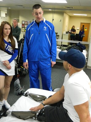Cadet’s speak with U.S. Army Staff Sgt. Brian Mast in the rehabilitation room of Walter Reed National Military Medical Center Bethesda. The Air Force Academy cheerleaders and a few football players went to WRNMMCB on 27 Dec. to meet with wounded warriors. (U.S. Air Force Photo/Leslie Finstein)