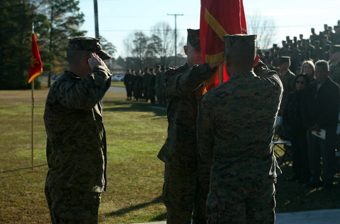 Sgt. Maj. John E. Bunkus, the sergeant major for 8th Engineer Support Battalion, 2nd Marine Logistics Group, salutes the battalion’s colors as Lt. Col. Christopher G. Downs, the outgoing commanding officer, passes them to Lt. Col. Ferdinand F. Llantero during a change of command ceremony at Soifert Field aboard Camp Lejeune, N.C., Dec. 29, 2011. During the ceremony, Downs relinquished his authority of the unit to Llantero. (U.S. Marine Corps photo by Pfc. Franklin E. Mercado)