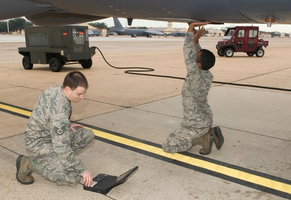 Staff Sgt. Andrew Dennis, 2nd Aircraft Maintenance Squadron, reads a technical order to Airman 1st Class Christopher Bellin, 2nd AMXS, as he conducts an entry hatch light checkout on a B-52H Stratofortress on Barksdale Air Force Base, La., Dec. 28. A technical order is a 'how-to' job reference guide used to ensure safety and accuracy. (U.S. Air Force photo/Senior Airman Kristin High)(RELEASED)