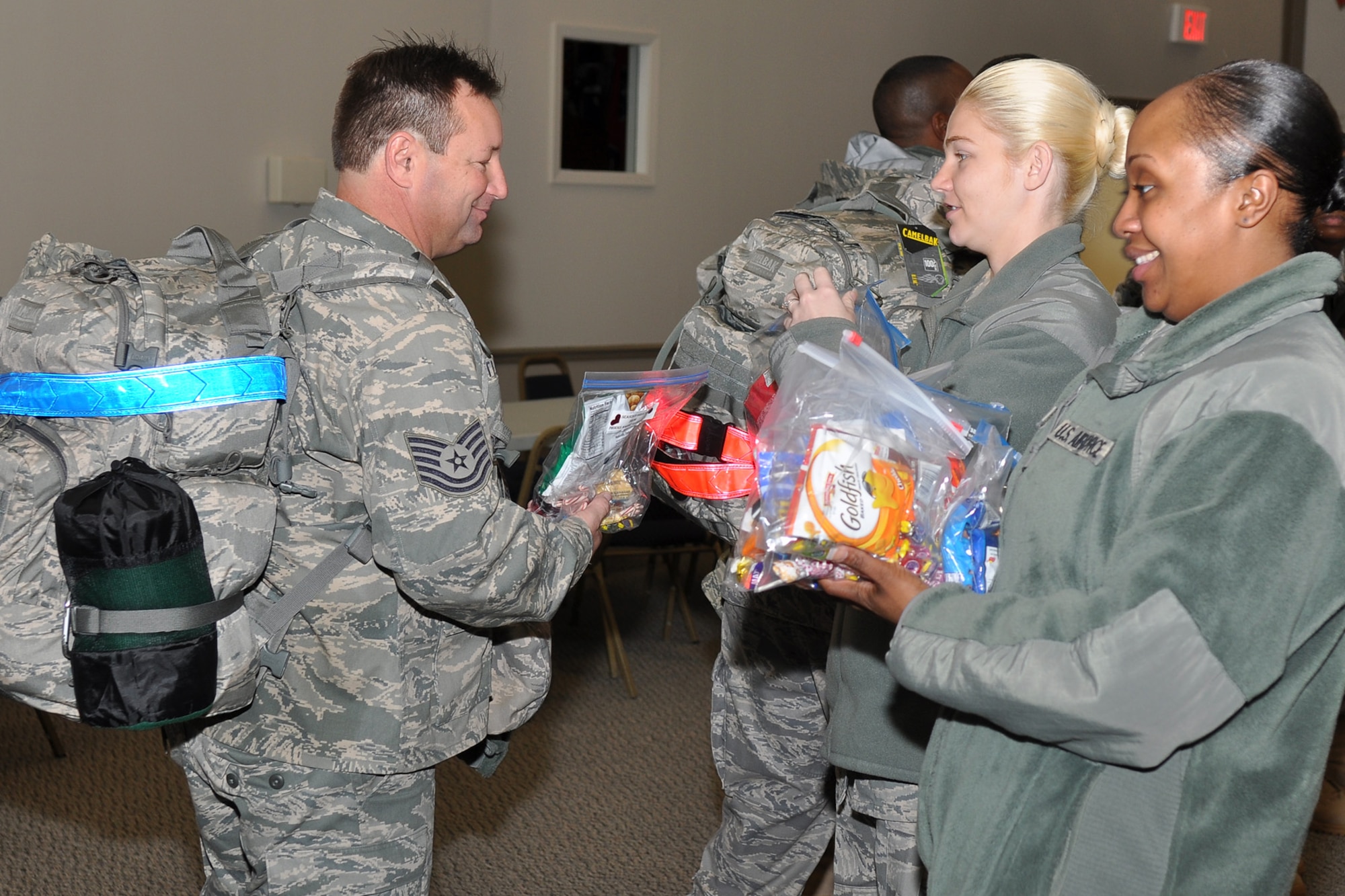 Tech. Sgt. Keith Castleberry, a jet engine mechanic assigned to the 917th Aircraft Maintenance Squadron, accepts a candy bag from Staff Sgt. Kathleen Thompson and Tech. Sgt. Breonna Parker at Hoban Hall on Barksdale Air Force Base, La., Dec. 28, 2011. Castleberry is just one of approximately 124 Airmen who deployed to Afghanistan in support of Operation Enduring Freedom. The bags of candy were donated by the First Shirt School. The 917th Fighter Group is an A-10 Thunderbolt II Air Force Reserve unit. (U.S. Air Force photo by Master Sgt. Jeff Walston)
