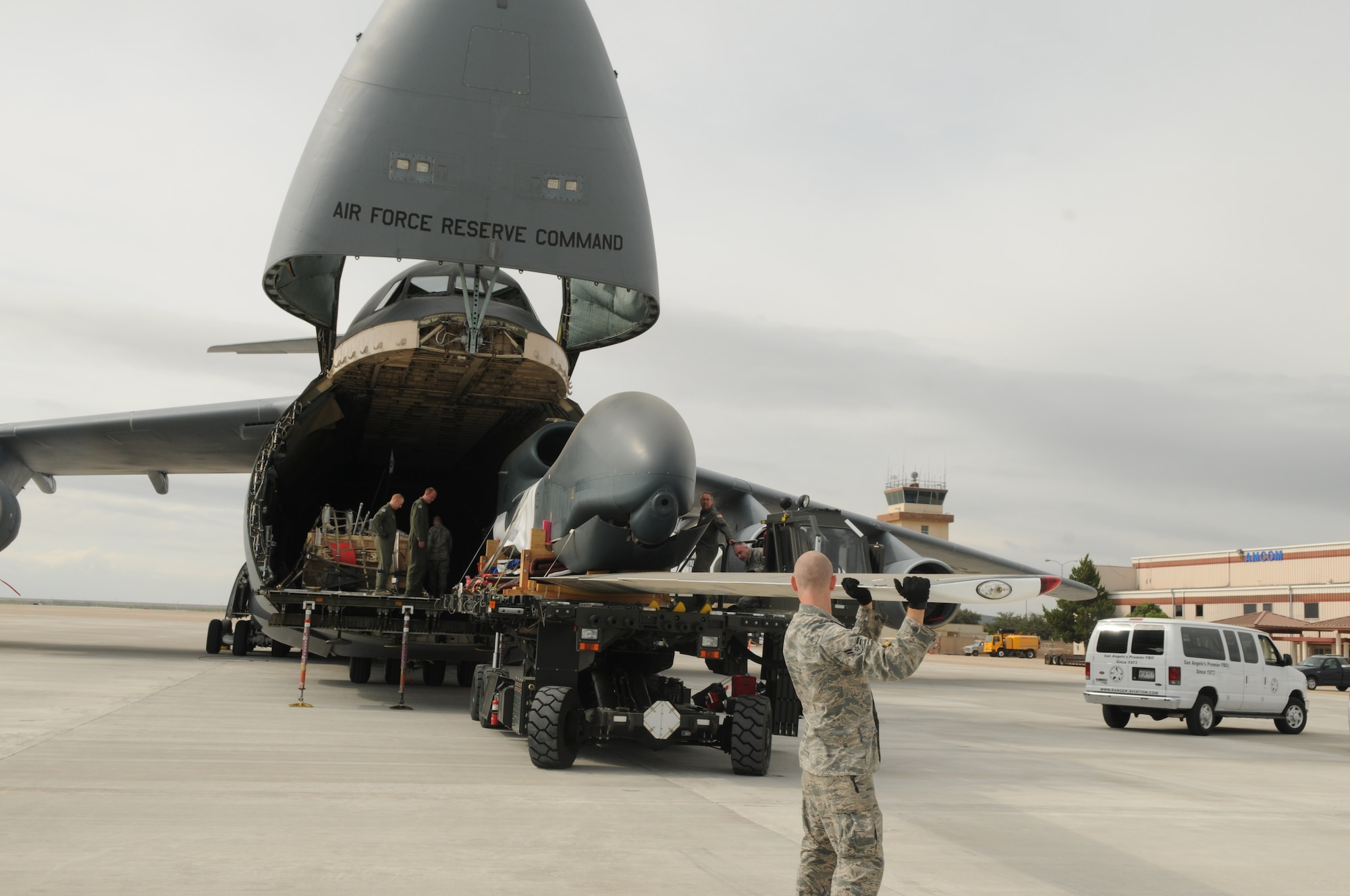 SAN ANGELO, Texas – Airman 1st Class Corey Travis, from the 97th Logistics Readiness Squadron, Altus Air Force Base, Okla., guides the wing of an RQ-4 Global Hawk as it is unloaded from a C-5 Galaxy, at San Angelo Regional Airport/Mathis Field, Sept 14, 2011. The aircraft transported two decommissioned RQ-4 Global Hawk drones from Beale Air Force Base, Calif. These drones are the first of their kind to be used as static displays, one of which will be at Goodfellow Air Force Base, Texas. (U.S. Air Force Photo /Senior Airman Heather L. Rodgers)