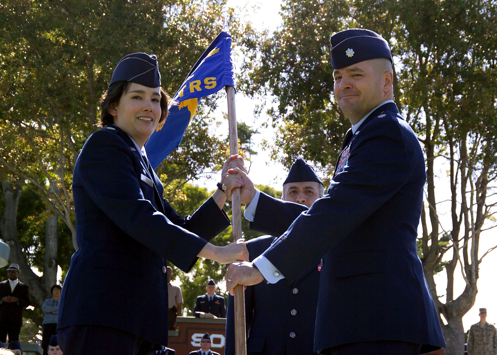 PRESIDIO OF MONTEREY, Calif. -- (From left:) Then Lt. Col. Laura Ryan, 517th Training Group Commander, passes the 311th Training Squadron guidon to Lt. Col. Michels Pryor who assumed command of the 311th TRS from Lt. Col. Donna O’Harren during a change of command ceremony June 30, 2011. (Courtesy photo) 

