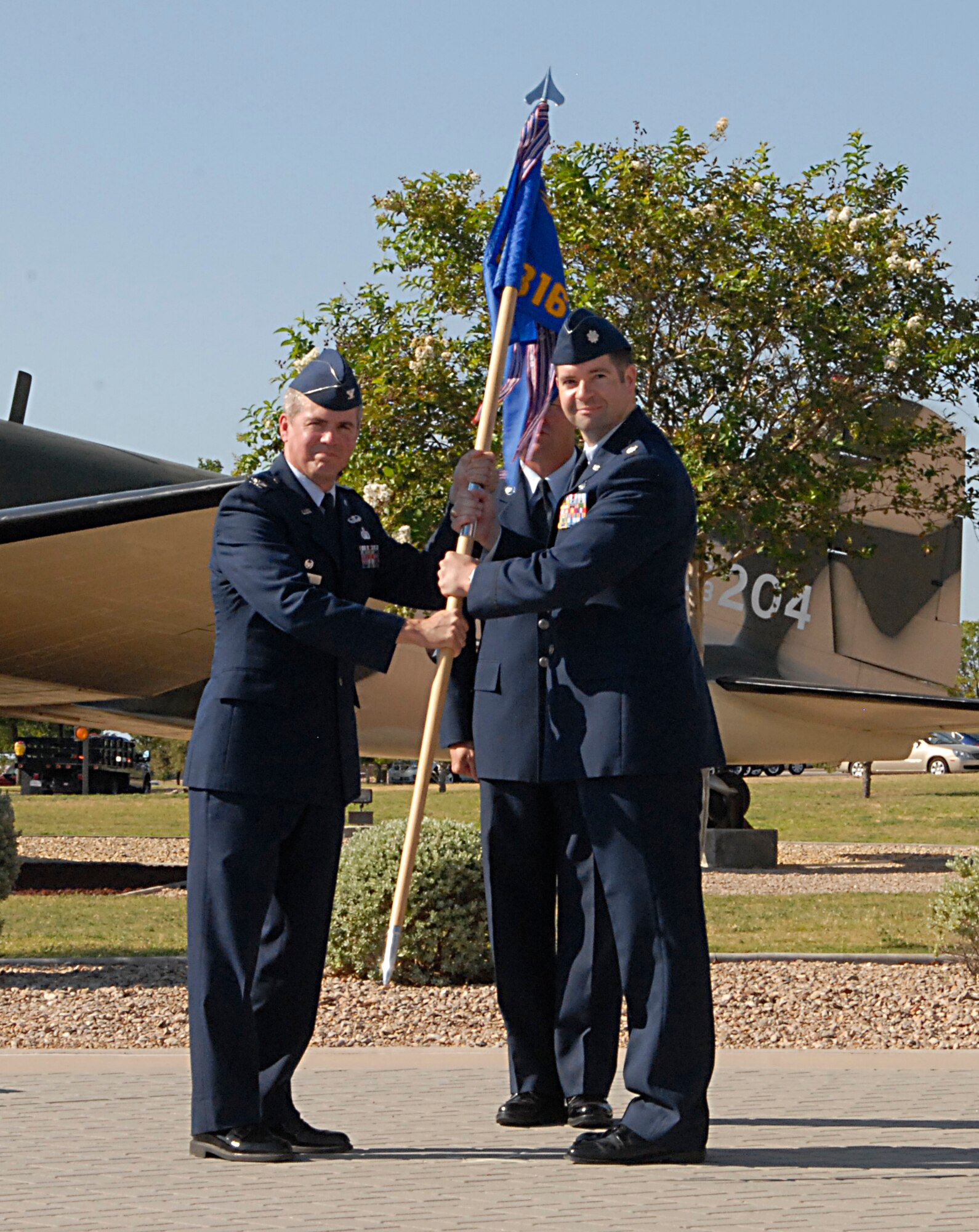 GOODFELLOW AIR FORCE BASE, Texas-- (From left:) Col. JD Willis, 17th Training Group Commander, passes the 316th Training Squadron guideon to Lt. Col. Scott J. Nahrgang who assumed command of the 316th TRS from Lt. Col. Erick J. Lawson during a change of command ceremony June 28, 2011 in front of the Norma Brown building here. (U.S. Air Force photo/Connie Hempel)