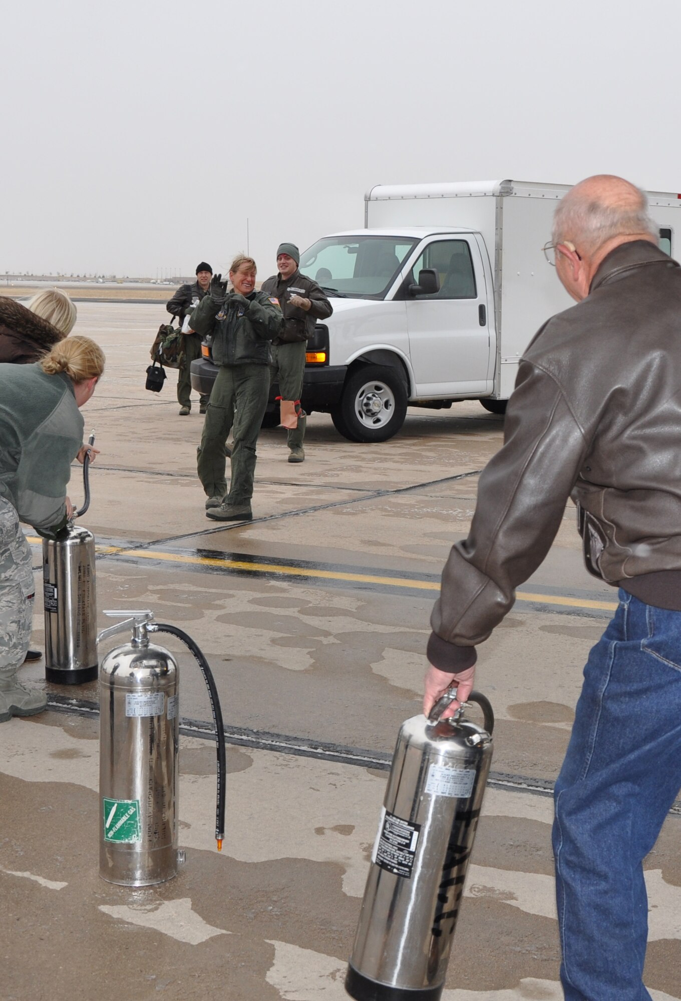 In an attempt to protect herself from the congratulatory water spray that is about to come her way, Col. Kathleen Flarity, 34th Aeromedical Squadron commander, raises her hands after completing her final flight Dec.19 at Peterson Air Force Base Colo. The colonel’s water dousing is a tradition conducted when a member of an aircrew completes their final flight with the unit they are assigned to. (U.S. Air Force photo/Ann Skarban)