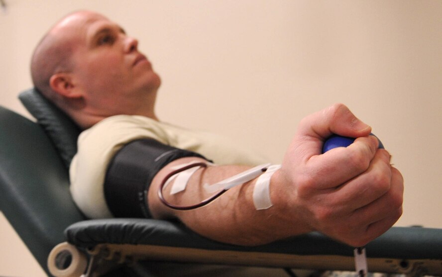 Tech. Sgt. Gregory Fuller, 2nd Communications Squadron quality assurance evaluator, squeezes a stress ball during a LifeShare blood drive at Hoban Hall on Barksdale Air Force Base, La., Dec. 28. Individuals who donate whole blood can give a unit every 56 days, while those who donate two units of red cells can contribute every 112 days.  (U.S. Air Force photo/2nd Lt. Tori Lalich)(RELEASED)
