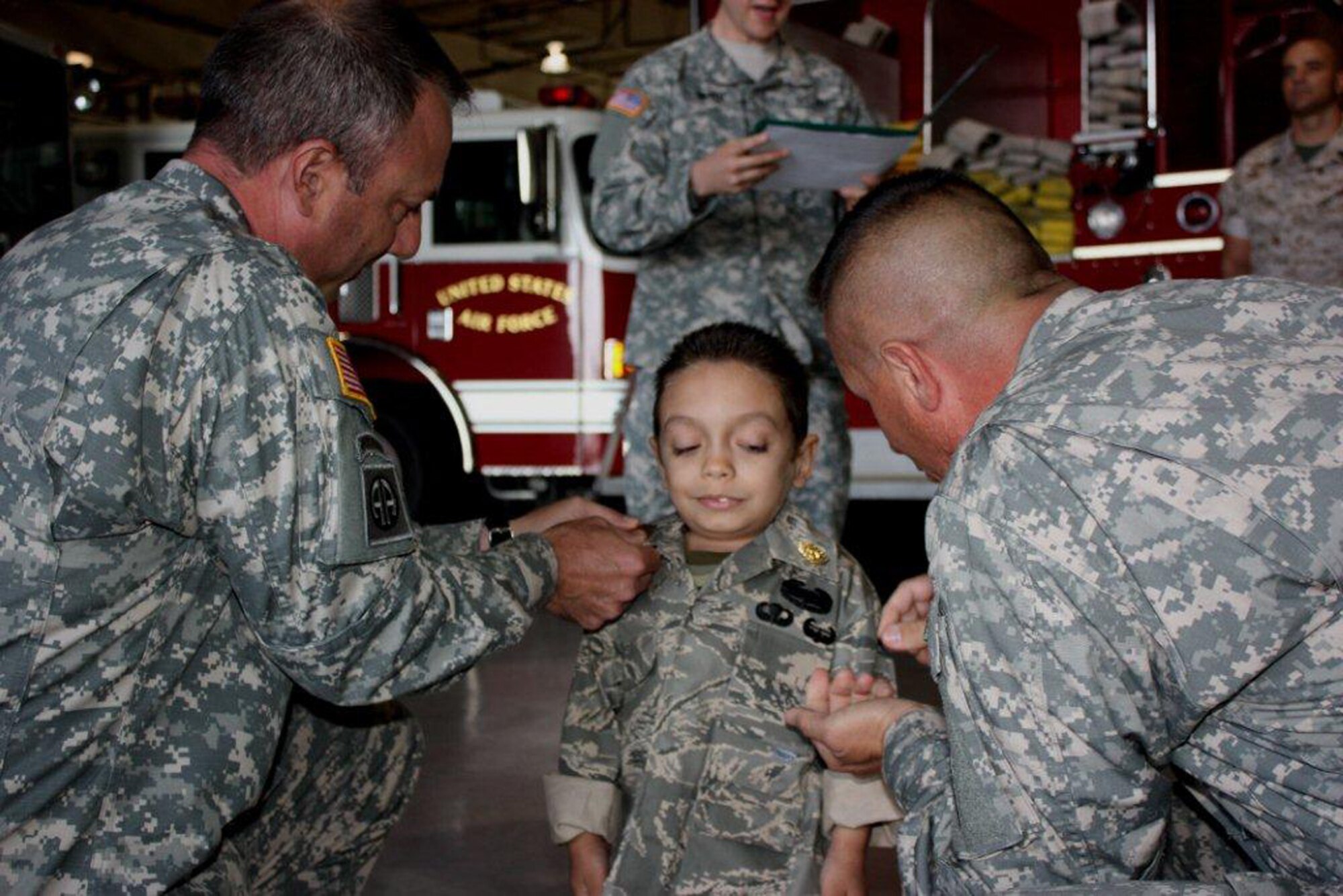 GOODFELLOW AIR FORCE BASE, Texas -- Shawn Chavez, 8, gets promoted to Sergeant Major by Army Lt. Col. John Bonin, 344th Military Intelligence Battalion Commander, and Command Sgt. Maj. Dan McCraw during his tour at the Louis F. Garland Fire Academy, Camp Sentinel and Afghan Village May 18, 2011. Servicemembers from the Army, Air Force, Navy and Marine Corps hosted Shawn and his family as part of the young boy's wish to meet a Soldier. (U.S. Army photo/Staff Sgt. Michael Carlson)