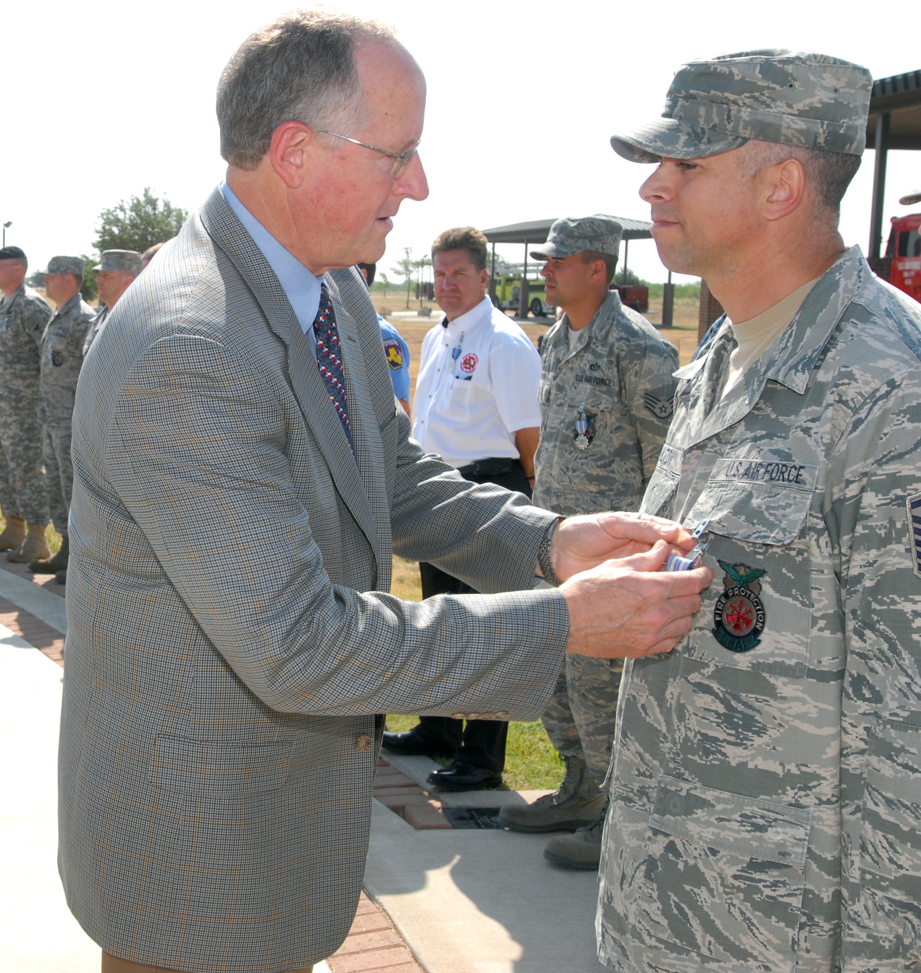 GOODFELLOW AIR FORCE BASE, Texas -- Master Sgt. Timur Hilton, 312th Training Squadron instructor, receives the Air Force Achievement Medal from Congressman Mike Conaway, 11th District of Texas, for his assistance in extinguishing the Texas Wildcat Fire May 18, 2011. Fifty-four Team Goodfellow Firefighters were awarded achievement medals for their assistance. (U.S. Air Force photo/Airman 1st Class Michael Smith)