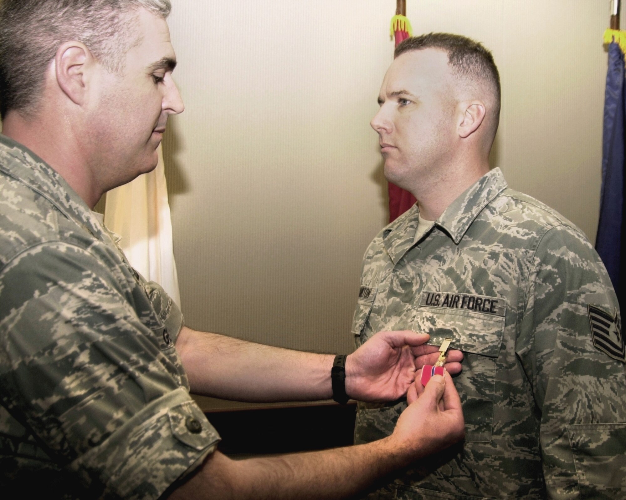 GOODFELLOW AIR FORCE BASE, Texas -- Col. Thomas Geary, then17th Training Wing Commander, presents Tech. Sgt. Thomas Hamilton, 17th Training Wing Judge Advocate Office, with a Bronze Star Feb. 22, 2011 for his achievements during a year-long deployment to Afghanistan. Hamilton was deployed as the first paralegal in the U.S. Forces-Afghanistan Commander's legal office and served as the NCO-in-charge. (U.S. Air Force photo/Connie Hempel)