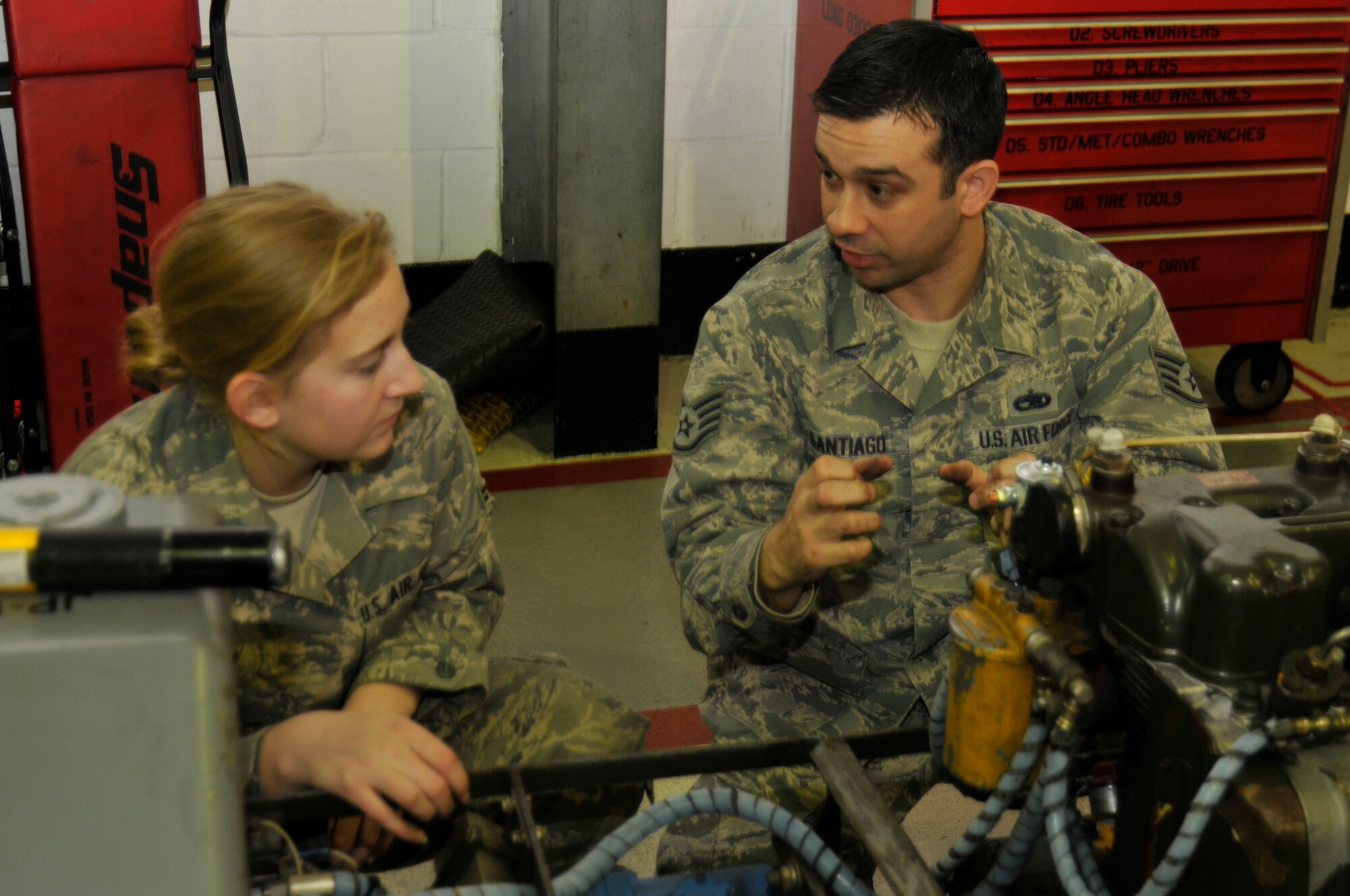 ROYAL AIR FORCE LAKENHEATH, England ? Staff Sgt. Nathan Santiago, 372nd Training Squadron, Detachment 16 Aerospace Ground Equipment instructor, describes the engine of a munitions handling truck to Airman 1st Class Ashley Cory, 48th Equipment Maintenance Squadron AGE apprentice, Dec. 29, 2011. Detachment 16 is responsible for the training of more than 2,000 48th Fighter Wing aircraft maintainers. (U.S. Air Force photo by Staff Sgt. David Dobrydney)