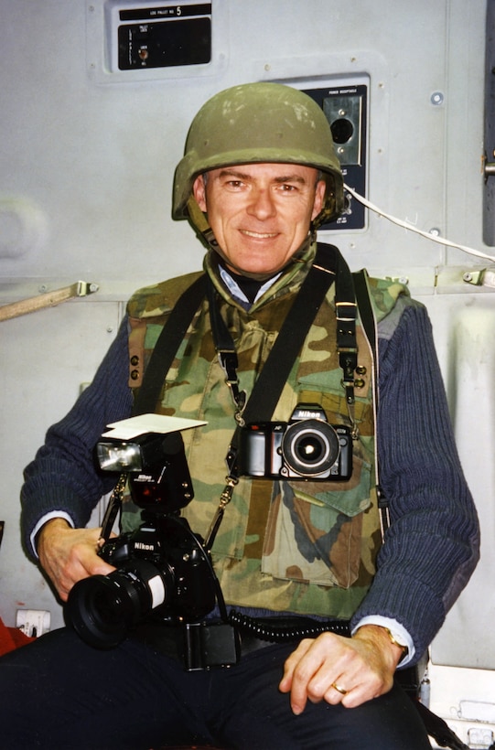 Pentagon photographer Robert D. Ward wears a flak vest and helmet aboard a C-17 airplane on final approach into Sarajevo, Bosnia, Jan. 3, 1996.  All passengers were require to wear protective gear as some landing aircraft had been recently fired upon by Serbian forces. Ward served as an official photographer to 12 defense secretaries, since 1974, retiring on Dec. 30, 2011.