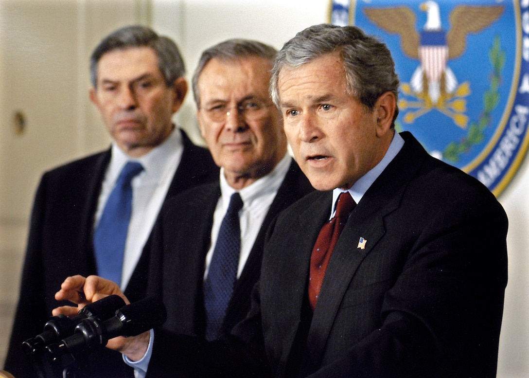 President George W. Bush, right, was back at the Pentagon on Sept. 17, 2001, to meet with Defense Secretary Donald H. Rumsfeld, Deputy Secretary of Defense Paul Wolfowitz, and the Joint Chiefs of Staff. They met to continue planning an appropriate military response to the al Qaeda threat.  They held a press conference after the meeting, where Defense Department photographer Robert D. Ward shot this picture of a very determined-looking president.