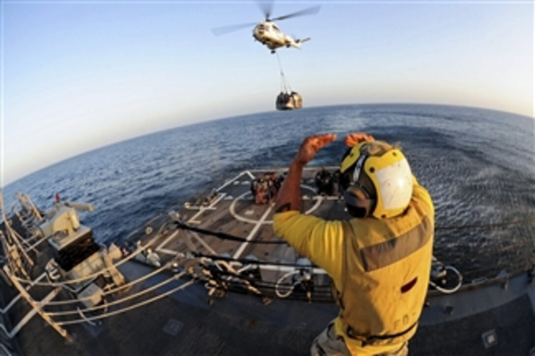 U.S. Navy Petty Officer 3rd Class Victor Hernandez, embarked upon the guided-missile destroyer USS Pinckney, directs an SA330J Puma helicopter during a vertical replenishment in the Gulf of Aden on Dec. 24, 2011.  The Pinckney is assigned to Combined Task Force 151, a multinational, mission-based task force working under Combined Maritime Forces, to conduct counter-piracy operations in the southern Red Sea, Gulf of Aden, Somali Basin, Arabian Sea and Indian Ocean.  