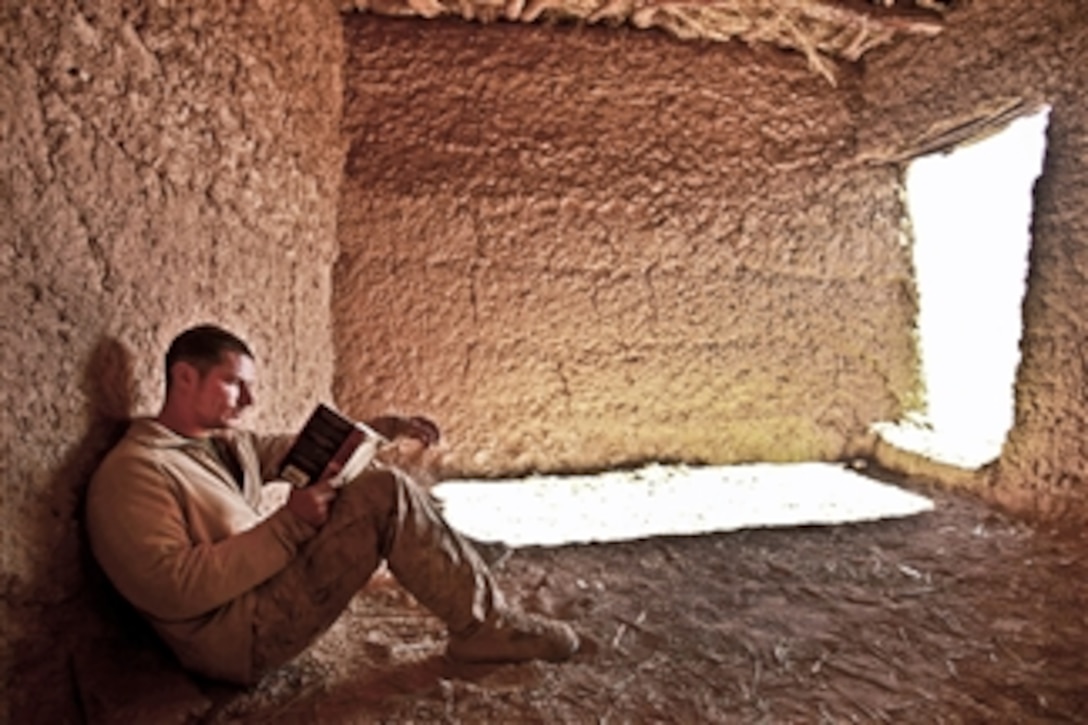 U.S. Marine Corps Cpl. David Gage relaxes inside a mud hut after a security patrol in Helmand province, Afghanistan, on Dec. 23, 2011.  Gage, an enlisted adviser, shares his knowledge as a military policeman with his Afghan counterparts.  