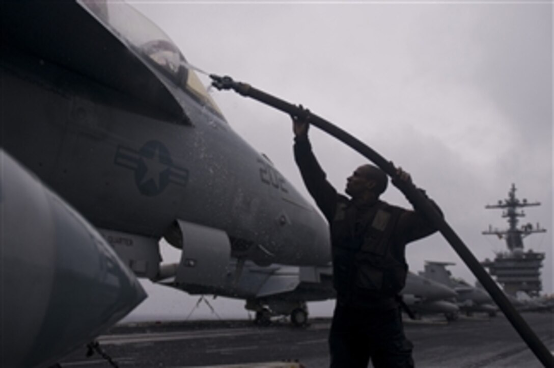 Airman Benjamin Ramsey, assigned to Strike Fighter Squadron 81, rinses an F/A-18E Super Hornet on the flight deck of the the aircraft carrier USS Carl Vinson (CVN 70) in the Pacific Ocean on Dec. 26, 2011.  The Carl Vinson and Carrier Air Wing 17 are underway on a western Pacific deployment.  