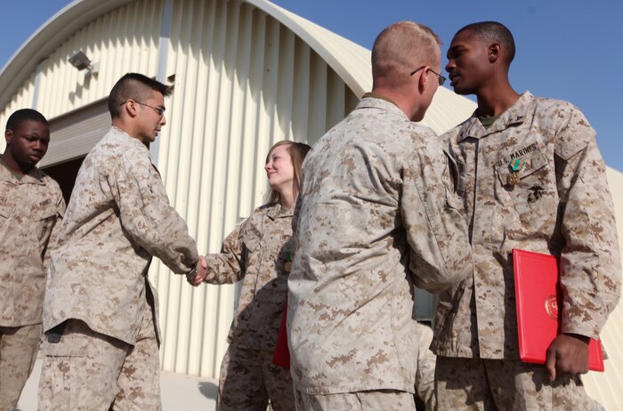 Lance Cpl. Caitlin E. Johnson, a native of Creswell, Ore., and Lance Cpl. Markevis J. Seth, a native of Wilmington, Del., are congratulated after receiving Navy and Marine Corps Achievement Medals aboard Camp Leatherneck, Afghanistan, Dec. 30. Both are attached to the MLG's Postal Detachment based aboard Camp Leatherneck, which is charged with delivering postmarked pieces of home to more than 22,000 military and Department of Defense personnel scattered across Regional Command Southwest's area of operation. The Marines performed admirably during the holiday season mail-rush. (U.S. Marine Corps photo by Sgt. Justin J. Shemanski)