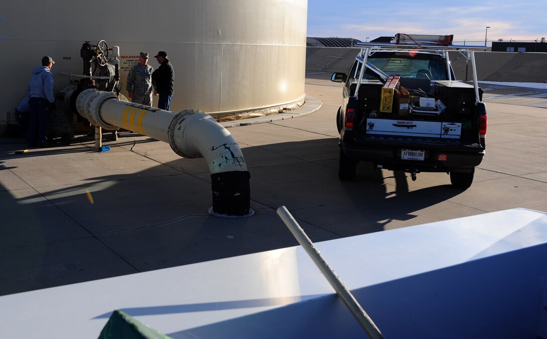 Civilian contractors and members of the 28th Civil Engineer Squadron prepare to replace and rewire the alarm system on a JP-8 fuel tank on Ellsworth Air Force Base, S.D., Dec. 28, 2011. These electronic alarm systems are vital to protecting the installation’s fuel supply detecting fires, perimeter intrusions or when the fuel level drastically drops. (U.S. Air Force photo by Airman 1st Class Zachary Hada/Released) 