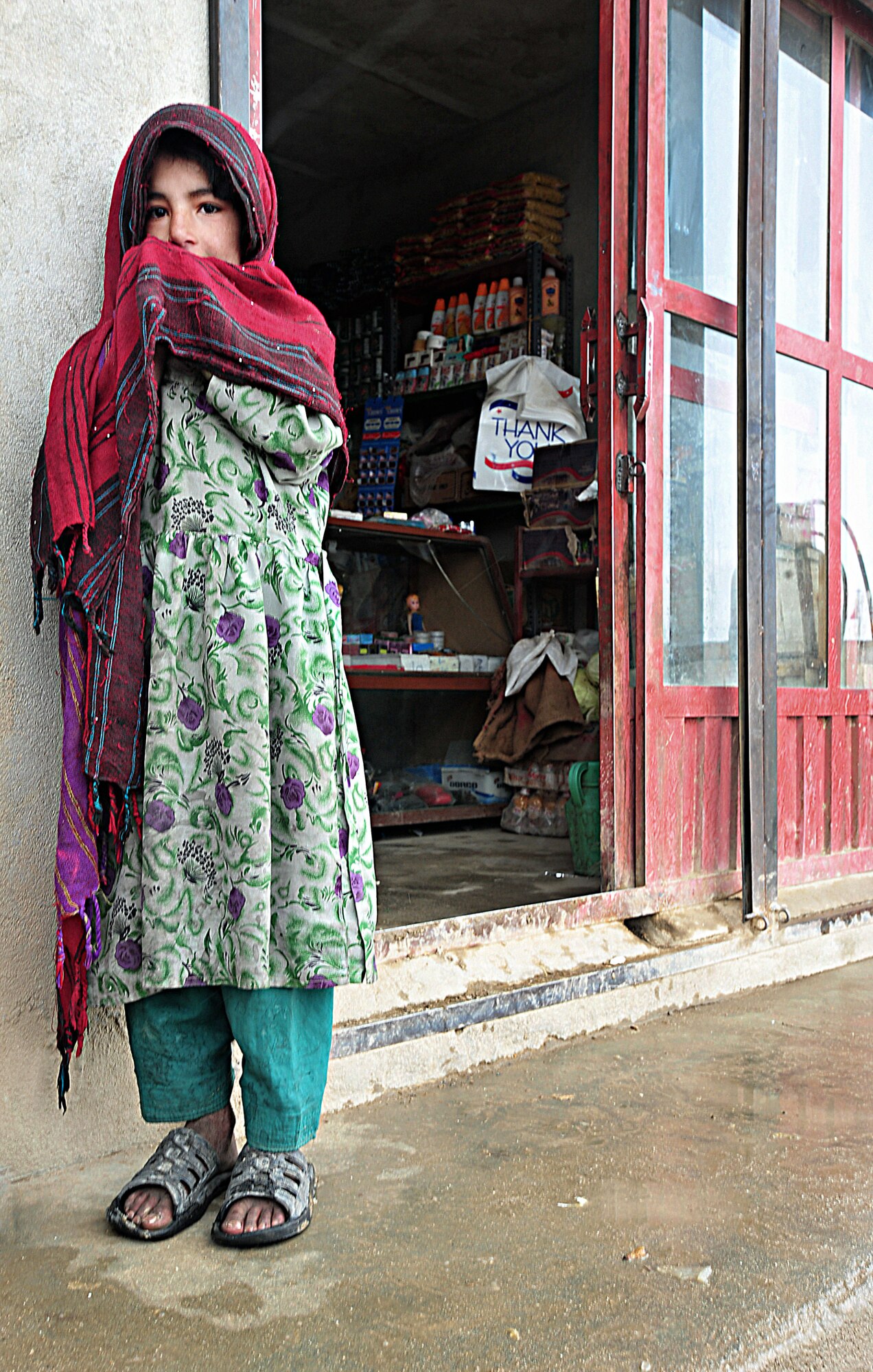 A little girl stands in front of a store in the Touheed Abad Village in Ghazni Province Feb. 6, 2011, during a Ghazni Provincial Reconstruction Team visit. The PRT visited the villiage to assess a water well and foster relationships. (U.S. Air Force photo/ Senior Airman Courtney)
