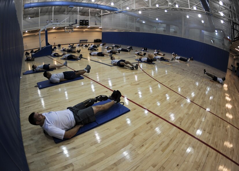 MINOT AIR FORCE BASE, N.D. -- Mike Schultz, MotoX and SnoX Athlete, works out his core with Minot Airmen here, Dec. 14. Schultz is part of the American300 Never Quit Tour. The American300 tour consists of amputees who fought through their physical disabilities to become outstanding athletes. The purpose of the tour is to encourage and build resiliency among U.S. Forces around the world. (U.S. Air Force photo/Senior Airman Ashley N. Avecilla)