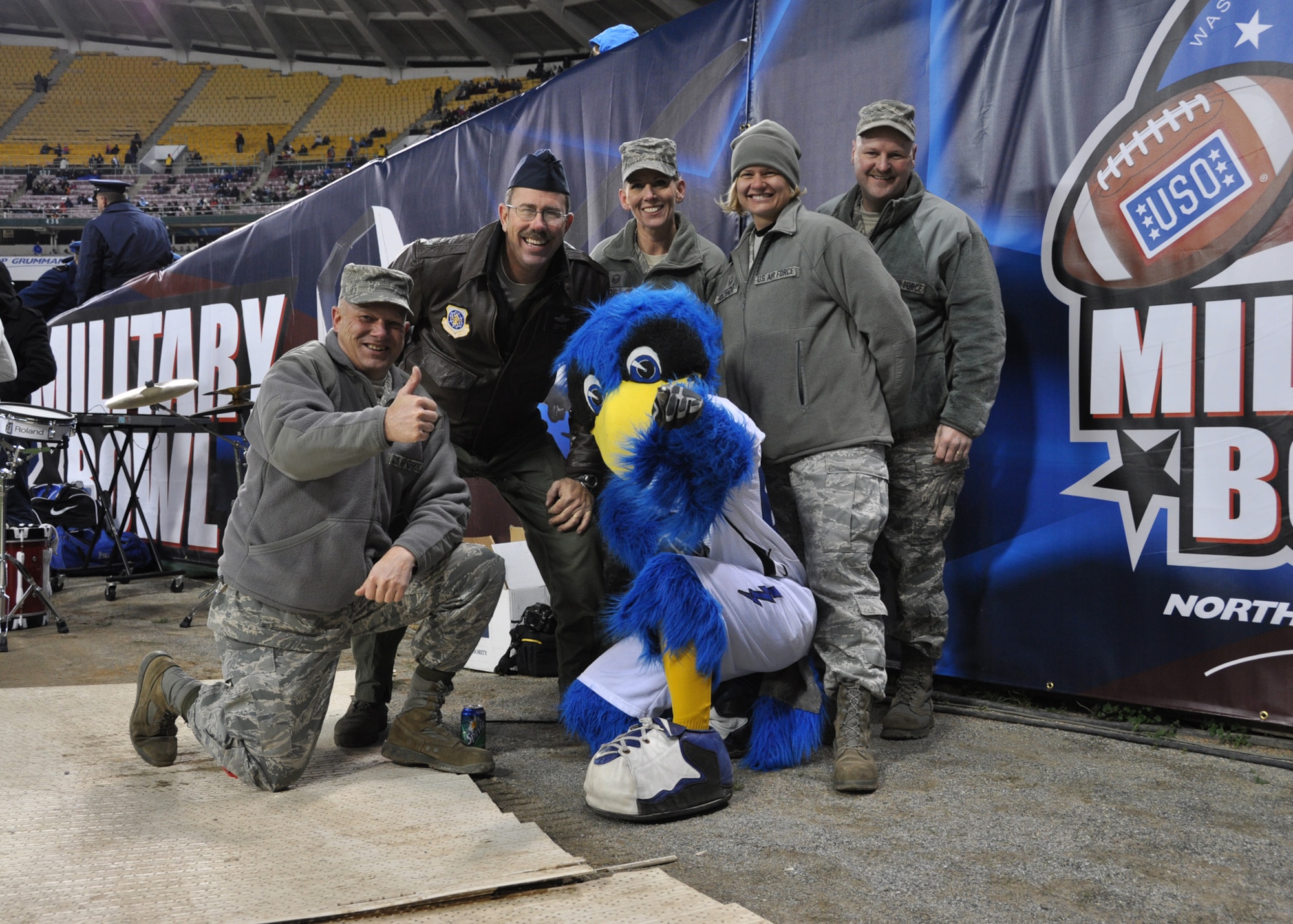 Airman from the 315th Airlift Wing assigned to Joint Base Charleston, S.C. take a moment to pose with the Air Force Academy's Falcon mascot at the 2011 Military Bowl at Robert F. Kennedy Stadium Dec. 28, 2011 in Washington, D.C. (U.S. Air Force photo/Senior Airman Bobby Pilch)