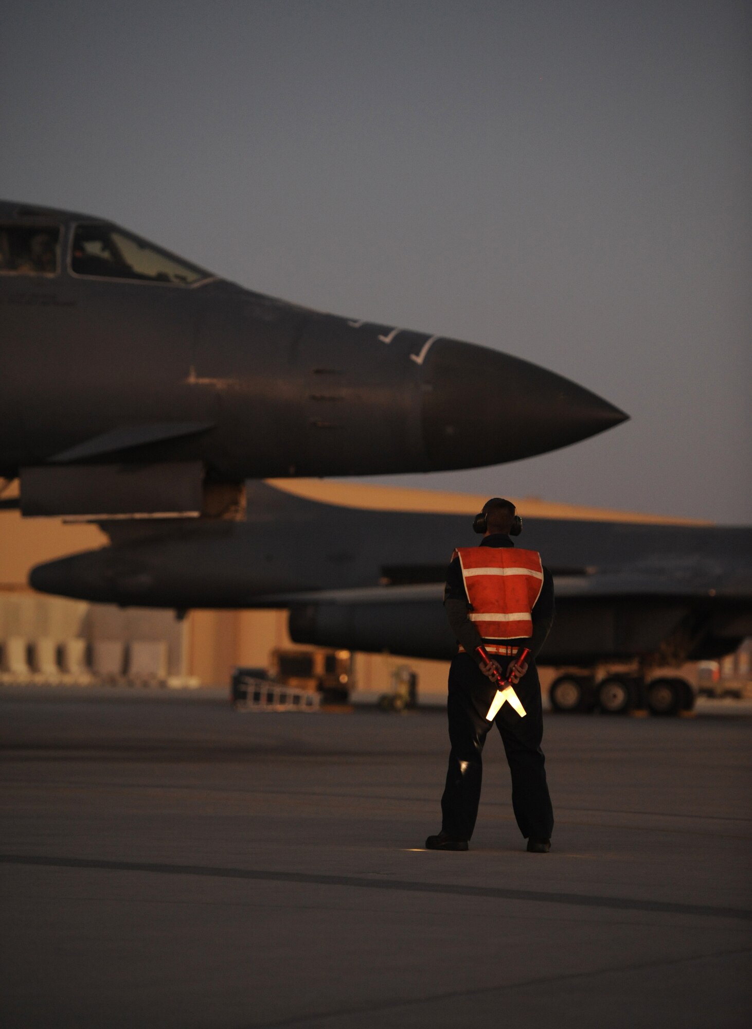 SOUTHWEST ASIA – Airman 1st Class Joseph Dowdell, 34th Expeditionary Aircraft Maintenance Unit and a native of Brunswick, Ohio, waits to marshal a B-1B Lancer onto the taxiway here Dec. 29, 2011. The B-1B is a long-range, multi-role bomber that can be used for a variety of operational missions. Dowdell is deployed from Ellsworth Air Force Base, S.D. (U.S. Air Force photo/Staff Sgt. Nathanael Callon)