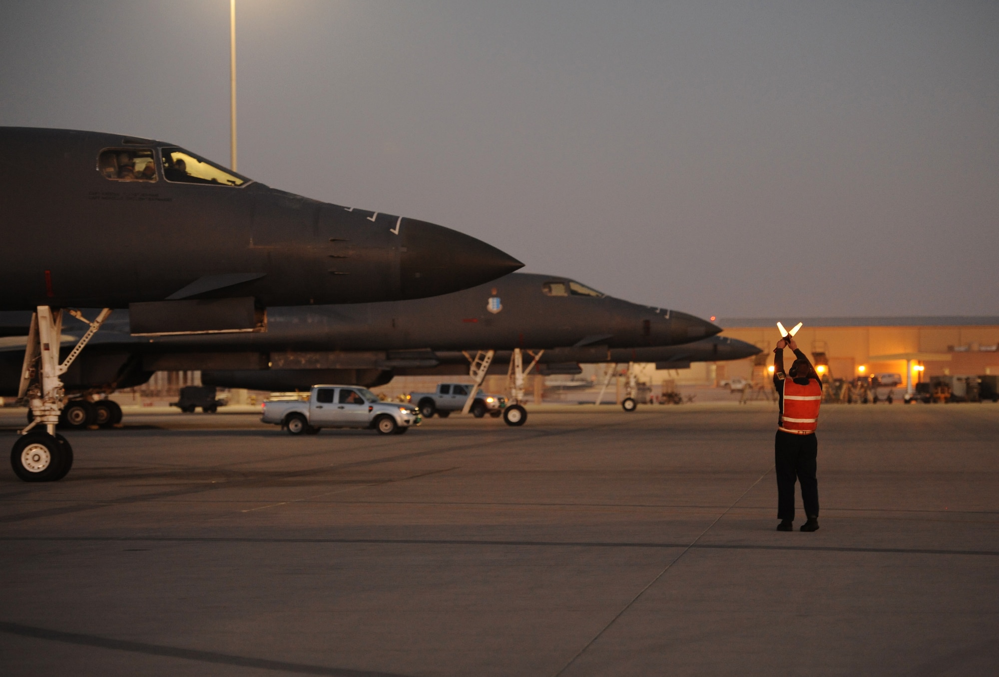 SOUTHWEST ASIA – Airman 1st Class Joseph Dowdell, 34th Expeditionary Aircraft Maintenance Unit and a native of Brunswick, Ohio, waits to marshal a B-1B Lancer onto the taxiway here Dec. 29, 2011. The B-1B is a long-range, multi-role bomber that can be used for a variety of operational missions. Dowdell is deployed from Ellsworth Air Force Base, S.D. (U.S. Air Force photo/Staff Sgt. Nathanael Callon)