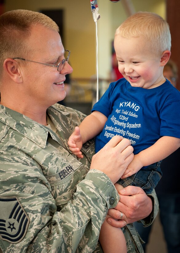 Master Sgt.Todd Edelen, a structural specialist in the Kentucky Air National Guard's 123rd Civil Engineering Squadron, tickles his son, Landon, in the Louisville International Airport passenger terminal in Louisville, Ky., June 25, 2011, after returning from a six-month deployment to Afghanistan. Sergeant Edelen was among more than a dozen 123rd CES Airmen who returned home on the same day, marking the first wave of more than 40 unit members who will be re-deploying from Bagram Airfield, Afghanistan, through July. The Kentucky Airmen comprised approximately 60 percent of Bagram's 455th Expeditionary Civil Engineer Squadron over the past six months, managing maintenance and construction for the 1,000-acre base and its 11,000-foot runway. The squadron completed more than 60 construction projects worth over $300 million during the deployment, including a new C-130 aircraft hangar, a 1,500-foot road and base housing for 500 personnel. (U.S. Air Force photo by Maj. Dale Greer)