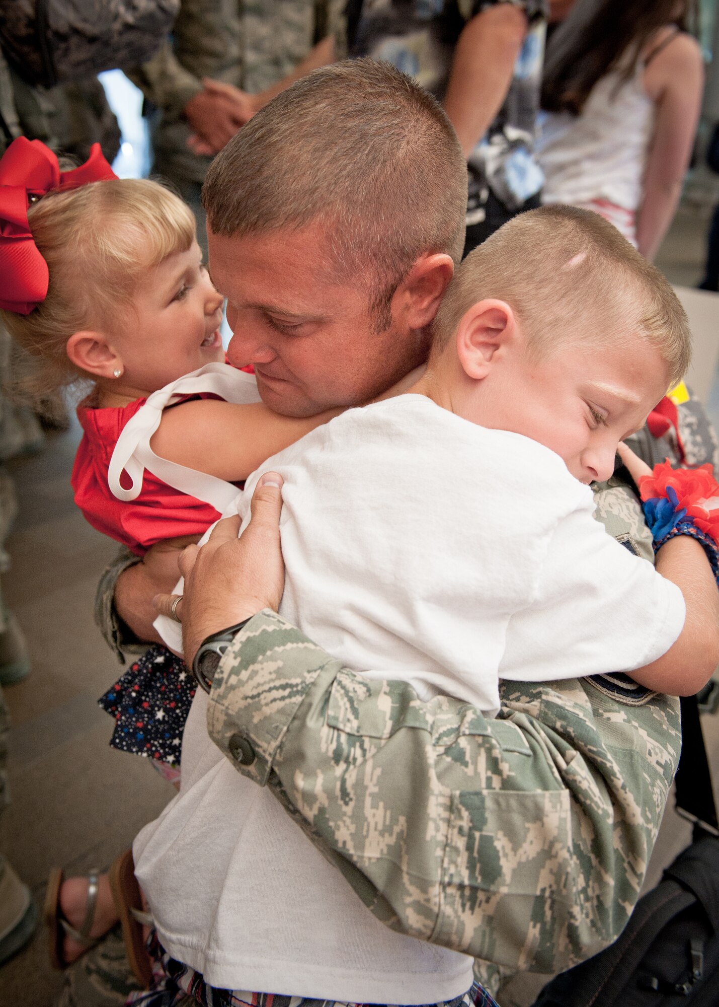 Master Sgt. Shaun Cecil, an electrician in the Kentucky Air National Guard's 123rd Civil Engineering Squadron, hugs his daughter, Caitlyn, and son, Trevor, in the Louisville International Airport passenger terminal in Louisville, Ky., June 25, 2011, after returning from a six-month deployment to Afghanistan. Sergeant Cecil was among more than a dozen 123rd CES Airmen who returned home on the same day, marking the first wave of more than 40 unit members who will be re-deploying from Bagram Airfield, Afghanistan, through July. The Kentucky Airmen comprised approximately 60 percent of Bagram's 455th Expeditionary Civil Engineer Squadron over the past six months, managing maintenance and construction for the 1,000-acre base and its 11,000-foot runway. The squadron completed more than 60 construction projects worth over $300 million during the deployment, including a new C-130 aircraft hangar, a 1,500-foot road and base housing for 500 personnel. (U.S. Air Force photo by Maj. Dale Greer)