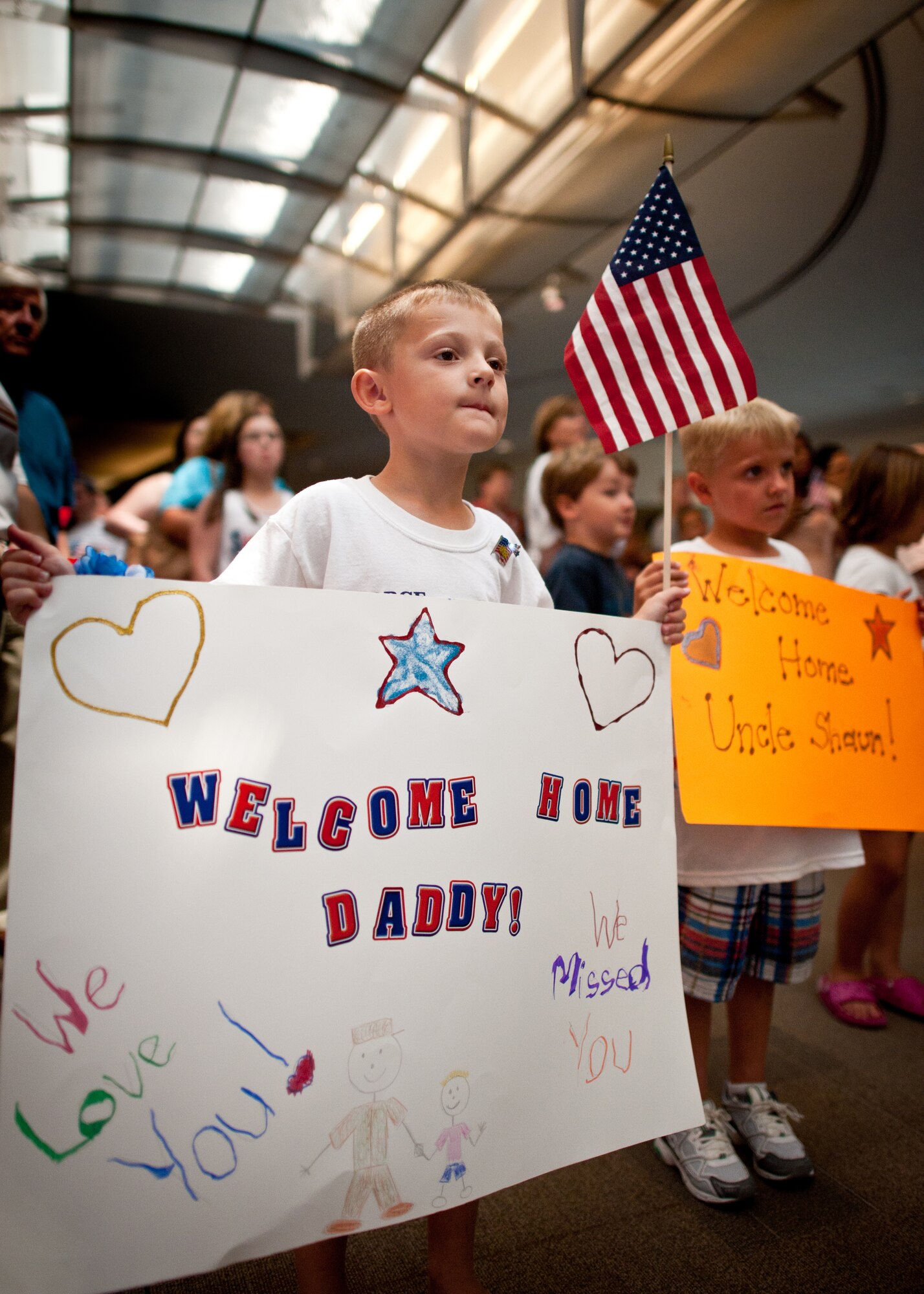 Trevor Cecil tries to catch a glimpse of his father, Kentucky Air National Guard electrician Master Sgt. Shaun Cecil, as the Airman walks down the aisle of the arrival terminal at Louisville International Airport in Louisville, Ky., on June 25, 2011. Sergeant Cecil and more than dozen of his coworkers were returning from a six-month deployment to Bagram Airfield Afghanistan, where they supported Operation Enduring Freedom as part of the 455th Expeditionary Civil Engineer Squadron. Their unit managed maintenance and construction for the 1,000-acre base and its 11,000-foot runway, completing over 60 construction projects worth more than $300 million during the past six months. (U.S. Air Force photo by Maj. Dale Greer)