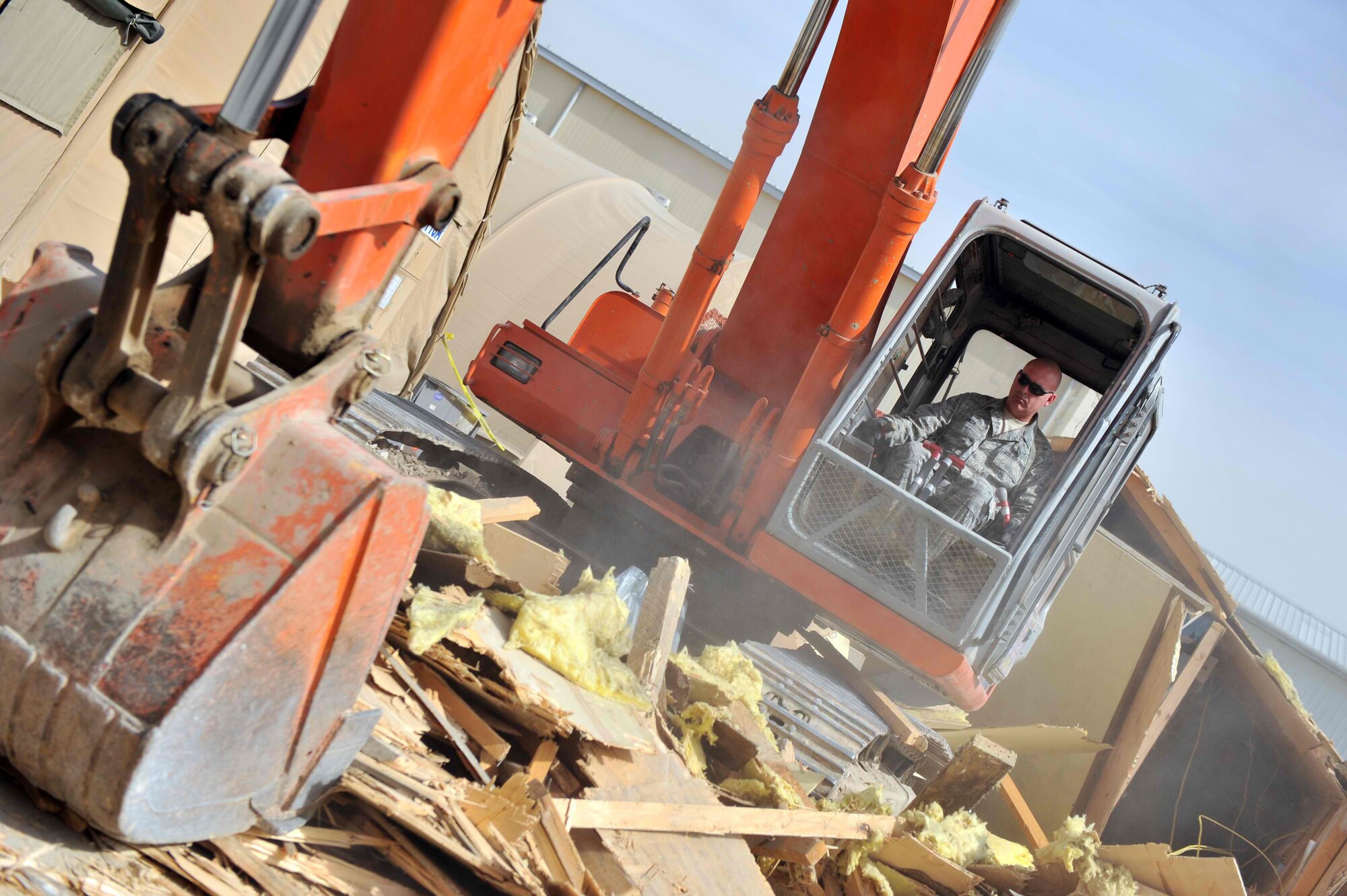 The Kentucky Air Guard's Tech Sgt. Gregory Smith uses an excavator March 16 to remove debris at Bagram Air Field, Afghanistan, while assigned to the 455th Expeditionary Civil Engineer Squadron. The 455th ECES cleared out a temporary structure to make way for new construction in support of Operation Enduring Freedom. Smith was deployed from the Kentucky Air Guard's 123rd CES. (U.S. Air Force by Senior Airman Sheila deVera)