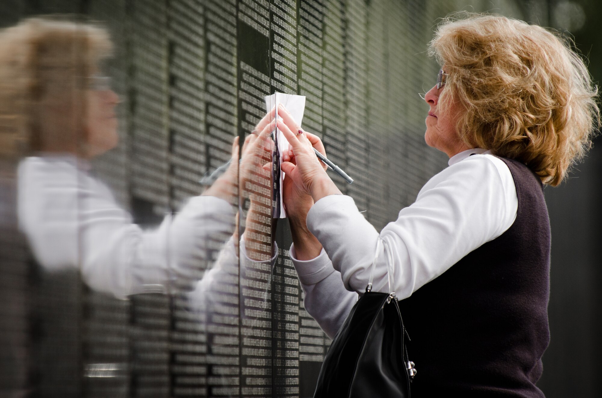 Jane Lee of Louisville, Ky., creates a rubbing from a soldier's name during closing ceremonies for the Dignity Memorial Vietnam Wall at Resthaven Memorial Park in Louisville, on Sept. 11, 2011. Lee, whose first husband served in Vietnam, chose the name at random because, she said, "everyone here is important -- each one of these people gave their all in service to our country." (U.S. Air Force photo by Maj. Dale Greer)