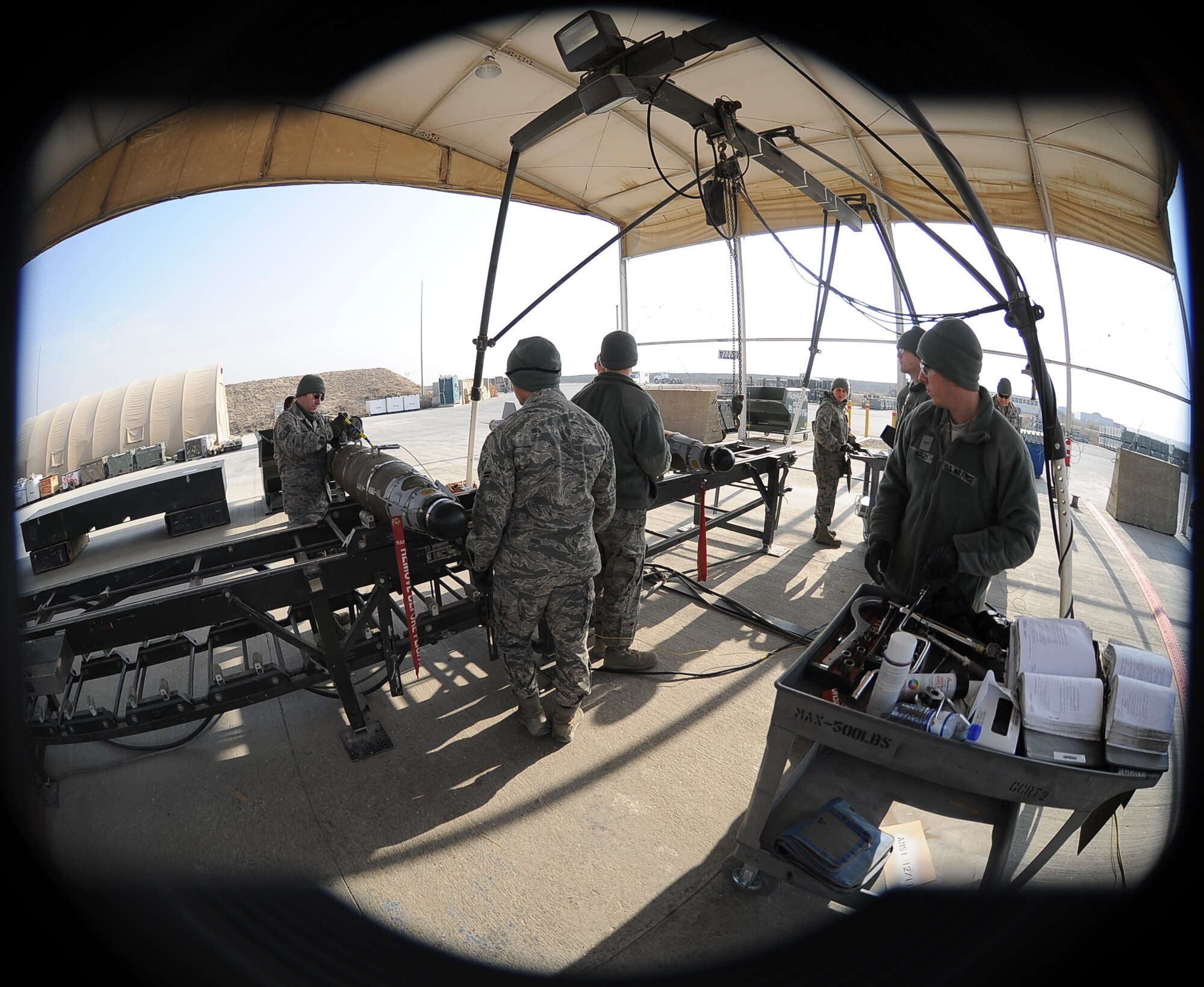 Munitions systems specialists from the 455th Expeditionary Maintenance Squadron use an AN/GYQ-79A to perform an integrated built-in test on the electronic components of two bombs undergoing an assembled munitions serviceability inspection at Bagram Airfield, Afghanistan, Dec. 28, 2011.  Munitions at Bagram are disassembled and the components are checked for proper functioning twice a year during an AMSI.  (U.S. Air Force photo/Tech. Sgt. Vernon Cunningham)