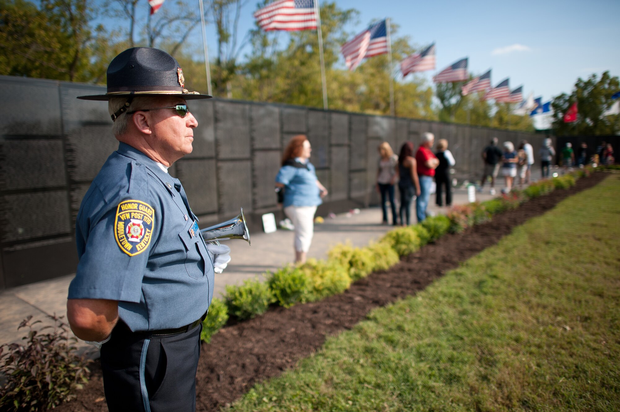 Visitors tour the Dignity Memorial Vietnam Wall at Resthaven Memorial Park in Louisville, Ky., on Sept. 11, 2011, as Ray Goings, vice commander of the Veterans of Foreign Wars Post 1170 in Middletown, Ky., stands at parade rest. The memorial is a 3/4-scale replica of the Vietnam Veteran's Memorial in Washington, D.C., and has been exhibited in more than 200 cities across the country since 1990. (U.S. Air Force photo by Maj. Dale Greer)