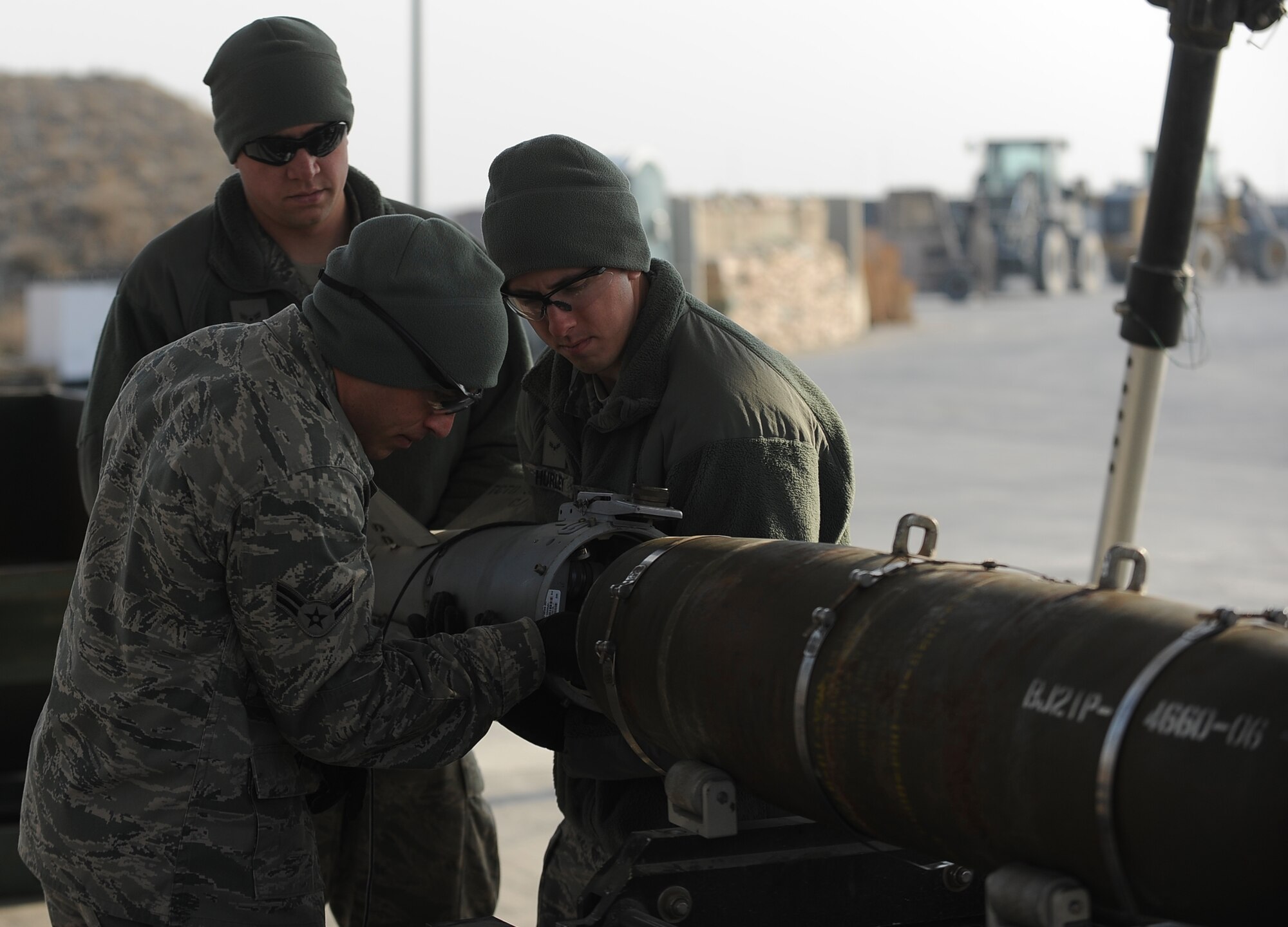 Airman 1st Class Joe LaGreca (left) and Airman 1st Class Braun Hurley (right) detach the tail of a bomb undergoing a semi-annual compliance inspection at Bagram Airfield, Afghanistan, Dec. 28, 2011.  The Ammo Airmen of the 455th Expeditionary Maintenance Squadron complete an assembled munitions serviceability inspection on all in-stock munitions every six months.  LaGreca is a Guardsman from Atlantic City, N.J.  Hurley is deployed from Seymour Johnson Air Force Base, N.C.  Both are munitions systems specialists with the 455th EMXS.  (U.S. Air Force photo/Tech. Sgt. Vernon Cunningham)