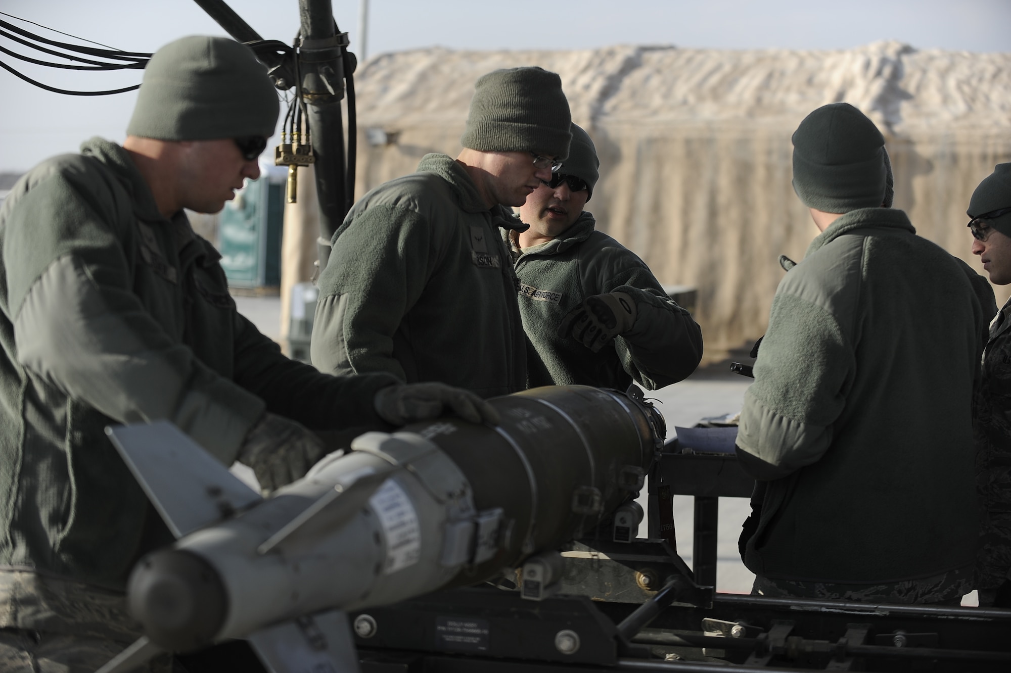 Staff Sgt. Alex Brzoska  (center) directs the disassembly of an MK-82 bomb during an assembled munitions serviceability inspection at Bagram Airfield, Afghanistan, Dec. 28, 2011.  An AMSI is performed every six months to ensure munitions are functional when they need to be used in combat.  Brzoska is a conventional maintenance supervisor with the 455th Expeditionary Maintenance Squadron.  (U.S. Air Force photo/Tech Sgt. Vernon Cunningham)