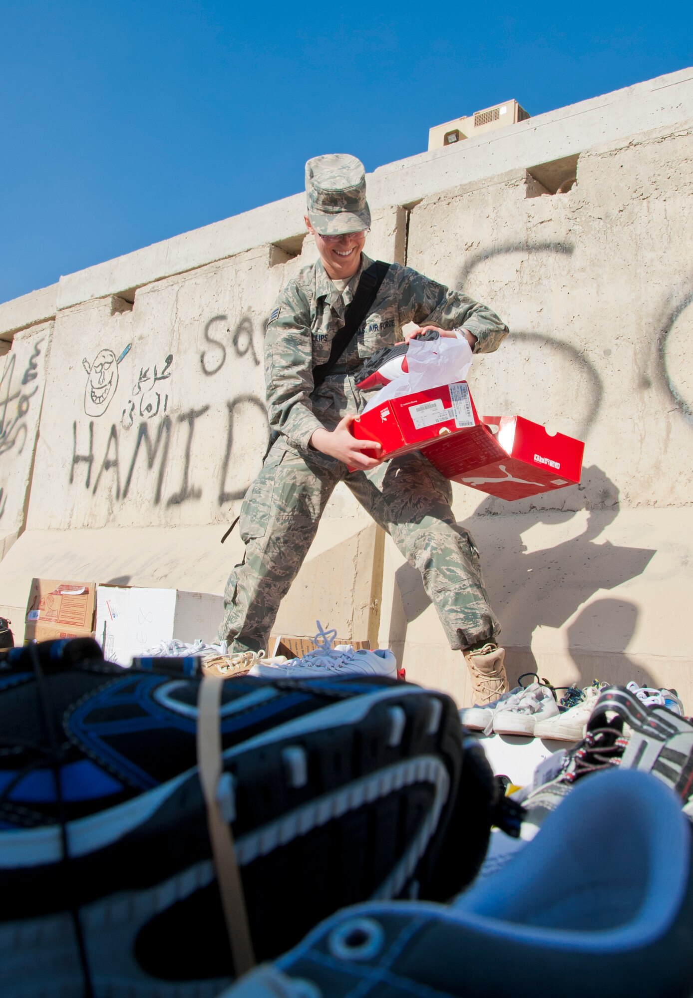 KANDAHAR AIRFIELD, Afghanistan -- Senior Airman Rachel Phillips looks for a specific shoe size for a local Afghan child at the Bazaar School at Kandahar Airfield, Afghanistan, Dec. 31, 2011. Volunteers throughout Kandahar collected more than 600 shoes to provide to children. The volunteers also fitted the children in the correct shoe sizes to educate them on the importance of proper shoe fitting. (U.S. Air Force photo by Staff Sgt. David Carbajal)