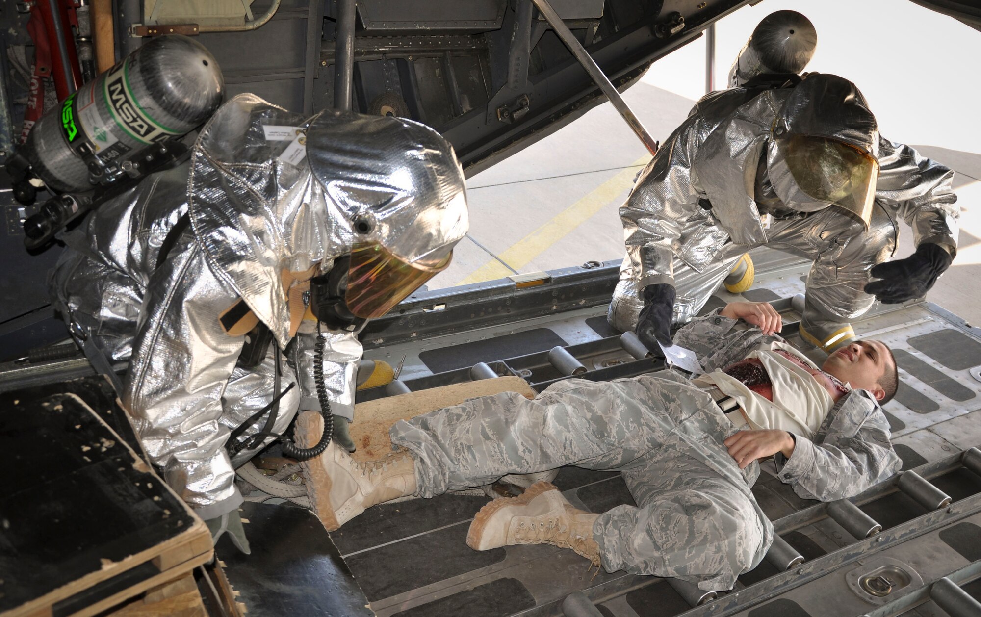 SOUTHWEST ASIA - 386th Expeditionary Civil Engineer Squadron firefighters assist a simulated casualty with severe burns, played by Senior Airman Kristopher Hawkins, a 386th Expeditionary Medical Group medical technician, during a major accident response exercise Dec. 29, 2011. Personnel base-wide took part in this MARE, which evaluated their ability to respond and recover from simultaneous major accidents. (U.S. Air Force photo/Staff Sgt. Michael McCool)