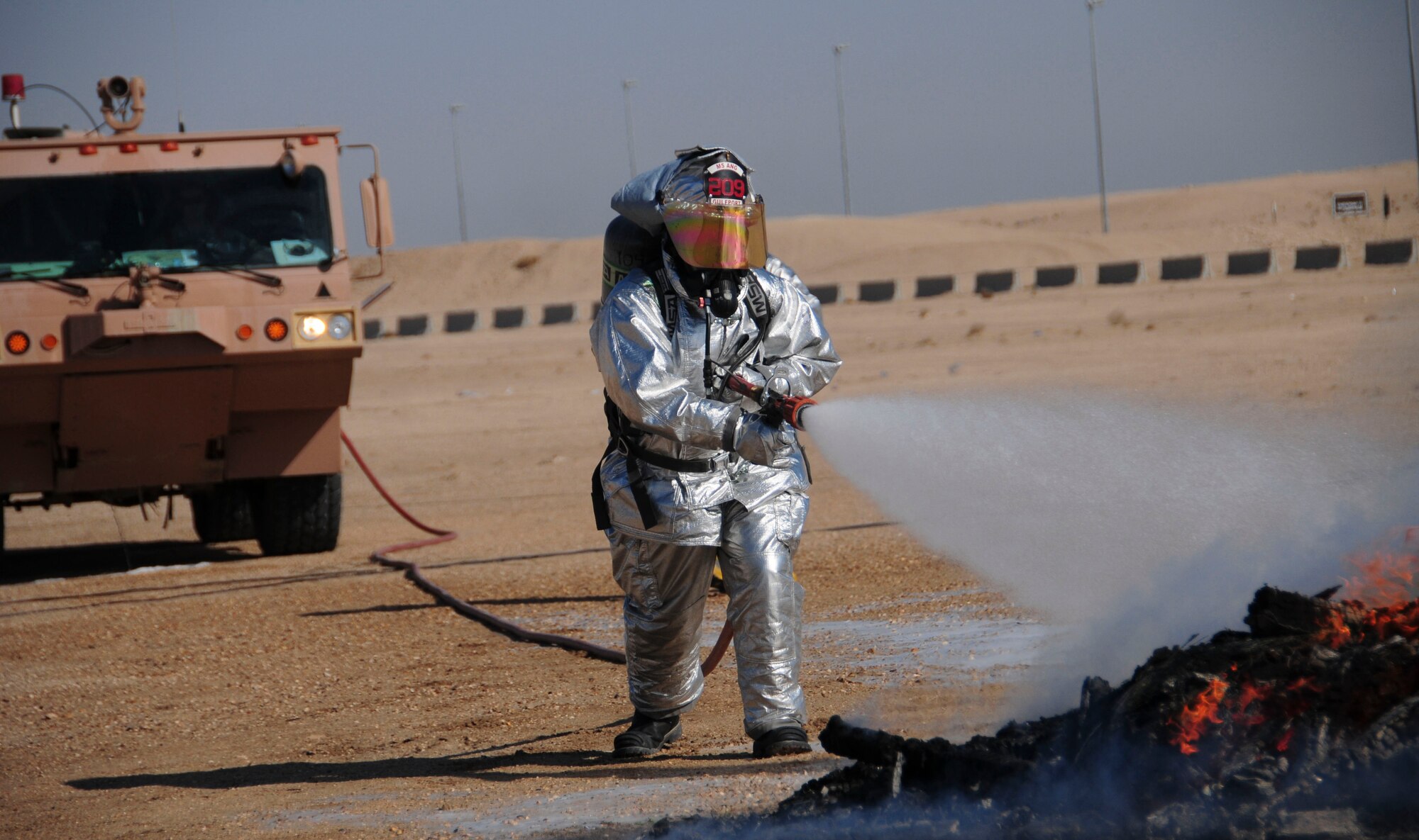 SOUTHWEST ASIA -- A firefighter with the 386th Expeditionary Civil Engineer Squadron extinguishes a fire, which was a simulated MQ-1 Predator aircraft after a simulated mid-air collision with another aircraft during a major accident response exercise Dec. 29, 2011. Personnel base-wide took part in this MARE, which evaluated their ability to respond and recover from simultaneous major accidents. (U.S. Air Force photo/Staff Sgt. Peter Ising)