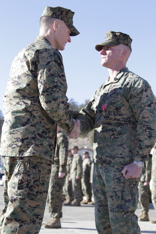 Gunnery Sgt. Matthew Nagel shakes hands with Col. Phillip Chandler, the commanding officer of Marine Corps Mountain Warfare Training Center Bridgeport, after receiving a Bronze Star Medal for meritorious achievement and combat service in Afghanistan, during an award ceremony Feb. 1, 2011, at the Center’s command post.