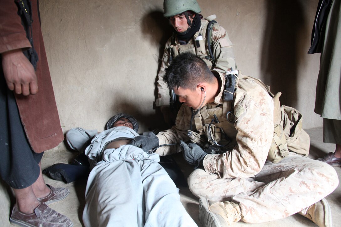 U.S. Navy Petty Officer 3rd Class Matthew Harter, a corpsman with 1st Platoon, Company I, Battalion Landing Team 3/8, 26th Marine Expeditionary Unit, Regimental Combat Team 2, examines an Afghan man complaining of stomach pain at a compound near Turah Shah Ghundey, Helmand province, Afghanistan, Feb. 1, 2011. Elements of 26th Marine Expeditionary Unit deployed to Afghanistan to provide regional security in Helmand province in support of the International Security Assistance Force.