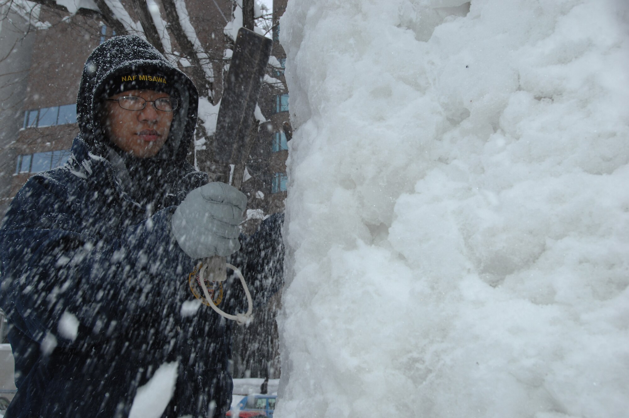 U.S. Navy Aviation Maintenance Administrationman Seaman Johnny Tran chops his way into a compacted block of snow as he and his Misawa Navy Snow Team members work toward creating an ice sculpture for the 62nd Annual Sapporo Snow Festival Feb. 1, 2011, Sapporo, Japan. Tran is stationed at Misawa Air Base and is attached to the Aircraft Intermediate Maintenance Detachment Misawa. (U.S. Navy photo by Chief Mass Communication Specialist Daniel Sanford/Released)