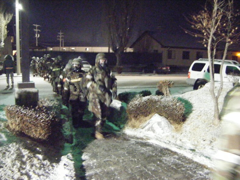 51st Logistics Readiness Squadron members make their way to the base theater for a "combat commander's call" during a training event Jan. 21. The training event included a recall response, and tested the squadron's ability to effectively transition through a chemically contaminated environment.(courtesy photo)