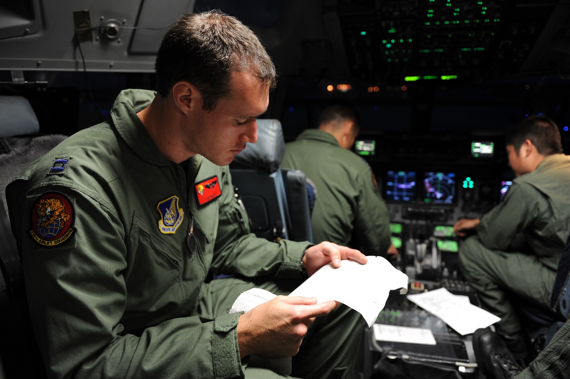 Capt. Jon Baize, 535th Airlift Squadron C-17 pilot, goes over paperwork in preparation for an airdrop mission with a U.S. Navy Maritime Craft Aerial Delivery System Jan. 13. Airmen from Joint Base Pearl Harbor-Hickam, Hawaii, teamed with Sailors from the Naval unit to deploy the boat off the coast of Guam while merging the capabilities of the U.S. Air Force and the U.S. Navy. (U.S. Air Force photo/Staff Sgt. Mike Meares)