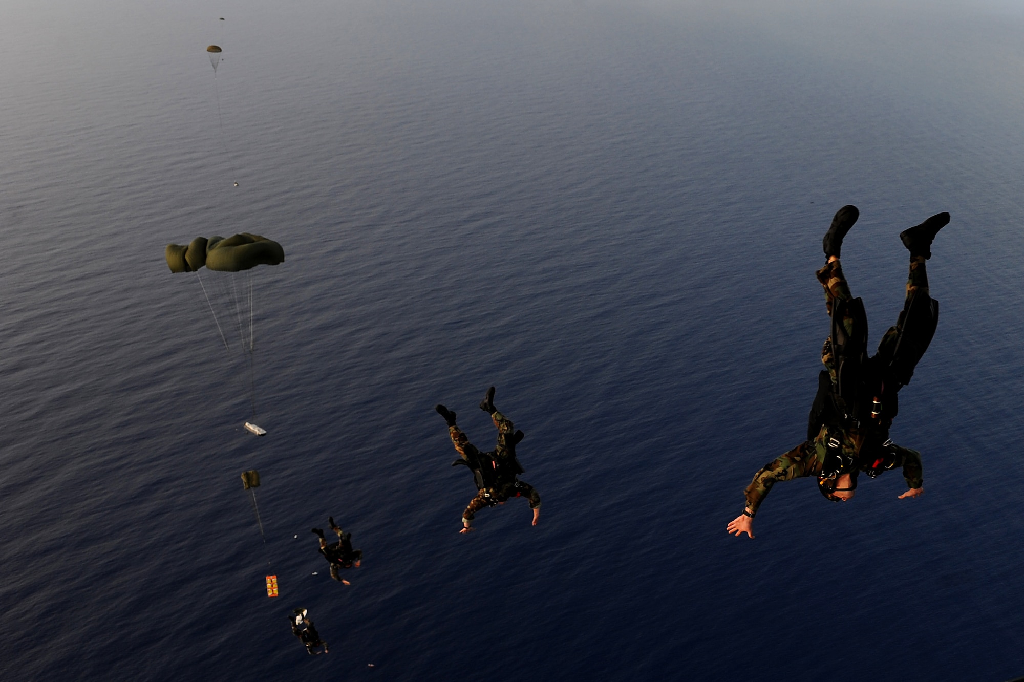 Navy Special Warfare Unit ONE jumpers bail out of the back of a C-17 Globemaster III after the aerial drop of a Maritime Craft Aerial Delivery System drop Jan. 13. Airmen from Joint Base Pearl Harbor-Hickam, Hawaii, worked with the Naval unit to deploy the boat off the coast of Guam while merging the capabilities of the U.S. Air Force and the U.S. Navy. (U.S. Air Force photo/Staff Sgt. Mike Meares)