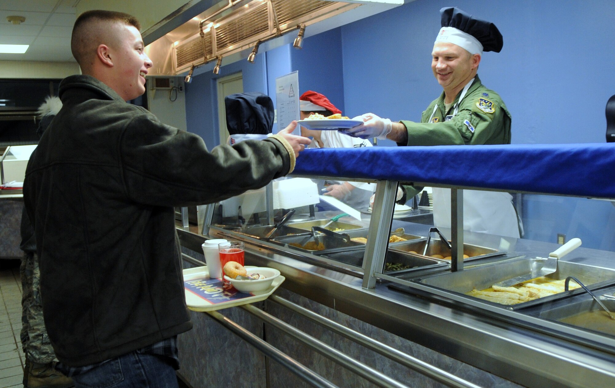 MINOT AIR FORCE BASE, N.D. -- Lt. Col. Donnie Holloway, 742nd Missile Squadron commander, serves a dinner plate to Airman 1st Class Joseph Metzger, 5th Security Forces Squadron security forces team member during the quarterly Airmen Appreciation Meal held at the Dakota Inn here Jan. 27. Base leadership volunteers to help serve special meals to Airmen for the AAM’s, showing appreciation for their efforts and contributions to the success of the mission here. (U.S. Air Force photo/Airman 1st Class Jose L. Hernandez)