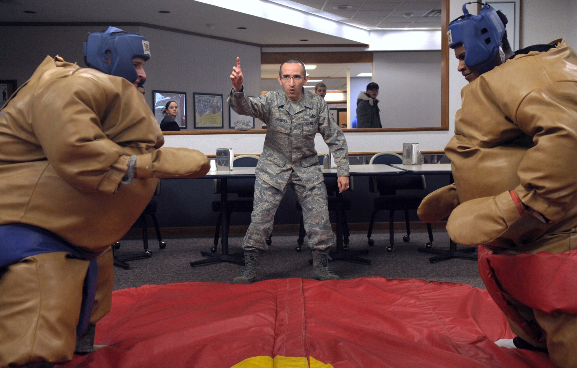 MINOT AIR FORCE BASE, N.D. -- Master Sgt. Jeimmy Bermudez, 5th Force Support Squadron food section chief, referees a sumo wrestling match between Airman 1st Class Aaron Rokow, 5th Comptroller Squadron customer service travel pay technician (left) and Airman 1st Class David Shuler, 5th Logistics Readiness Squadron vehicle operator (right) during the quarterly Airmen Appreciation Meal held at the Dakota Inn here Jan. 27. The Outdoor Recreation office provided sumo wrestling gear for the enjoyment of Airmen in attendance, as part of entertainment for that night. (U.S. Air Force photo/Airman 1st Class Jose L. Hernandez)