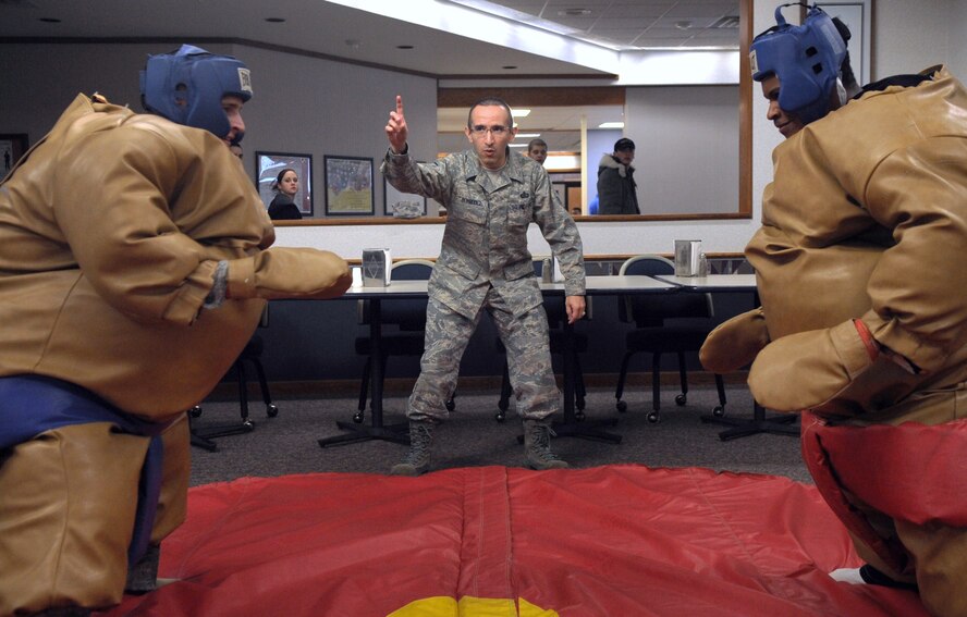 MINOT AIR FORCE BASE, N.D. -- Master Sgt. Jeimmy Bermudez, 5th Force Support Squadron food section chief, referees a sumo wrestling match between Airman 1st Class Aaron Rokow, 5th Comptroller Squadron customer service travel pay technician (left) and Airman 1st Class David Shuler, 5th Logistics Readiness Squadron vehicle operator (right) during the quarterly Airmen Appreciation Meal held at the Dakota Inn here Jan. 27. The Outdoor Recreation office provided sumo wrestling gear for the enjoyment of Airmen in attendance, as part of entertainment for that night. (U.S. Air Force photo/Airman 1st Class Jose L. Hernandez)